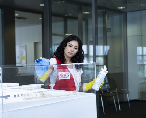 TKW Gebäudereinigung - Büroreinigung und Unterhaltsreinigung - Reinigungskraft reinigt Glasvitrine